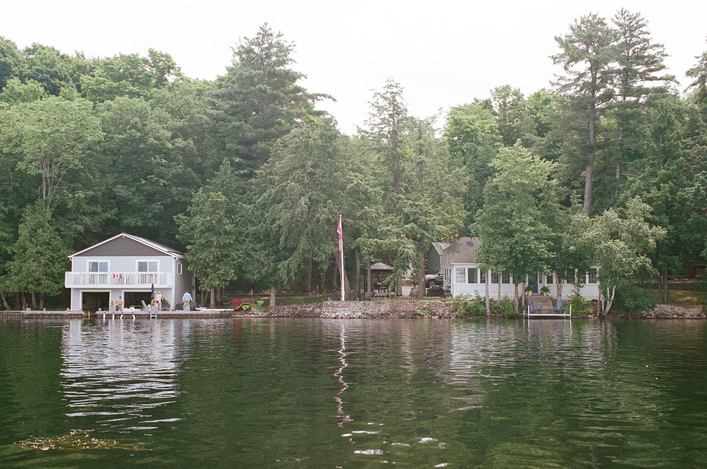 White cottages at the edge of the water under tall pines