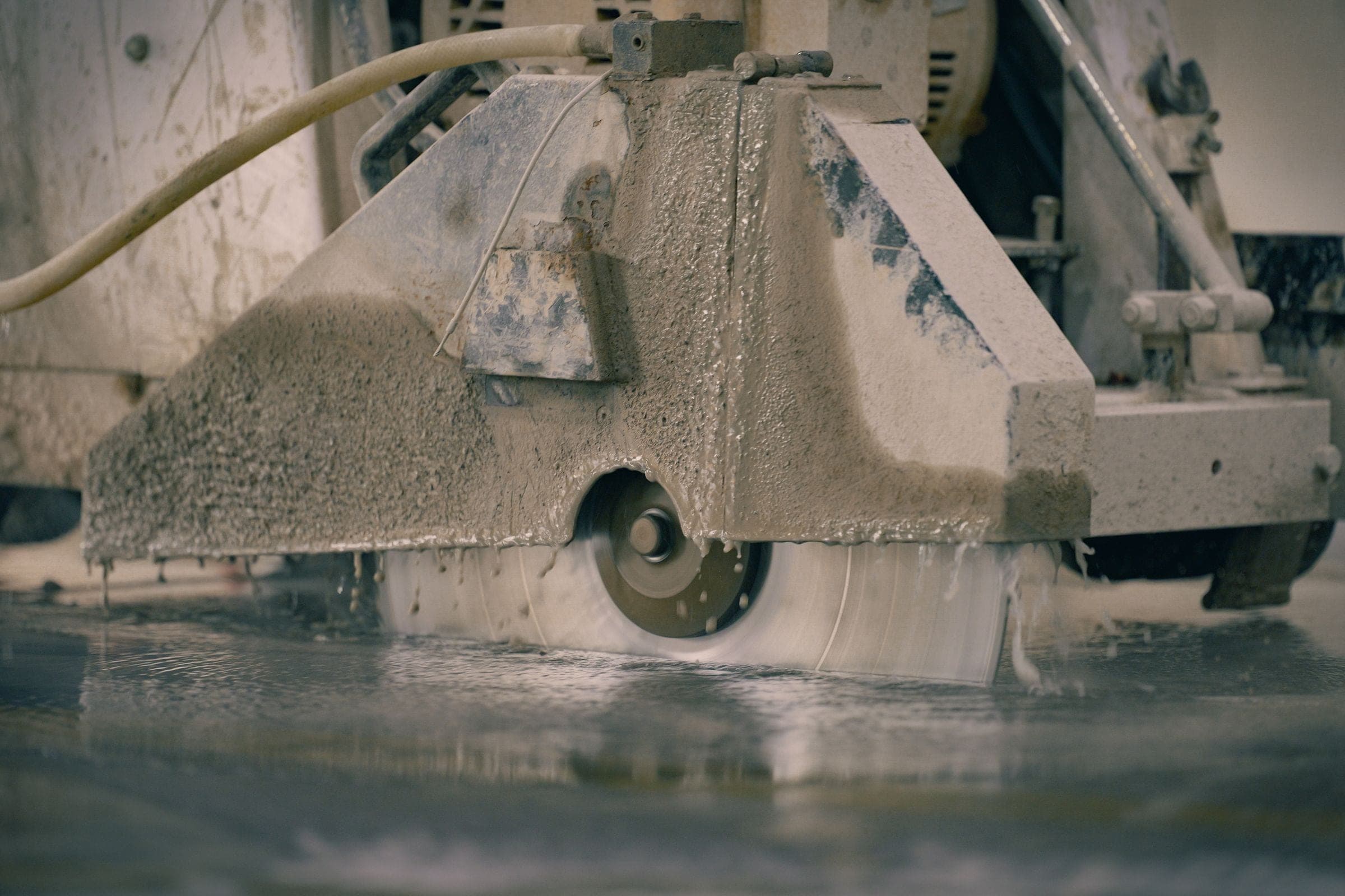 Concrete saw cutting a floor strip for interior basement waterproofing